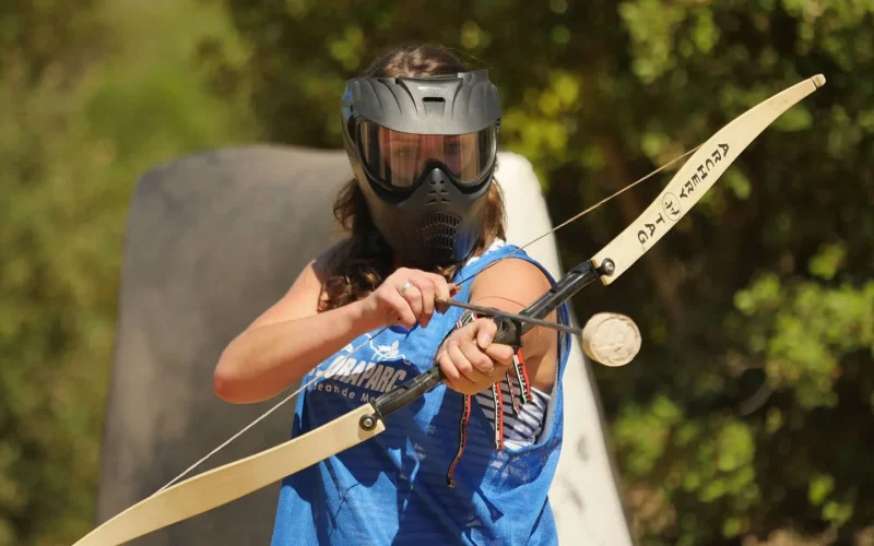 Eine Frau, die Archery Tag spielt